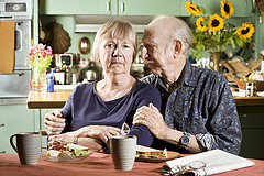 A senior couple seated on the dining area