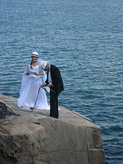 Just Married! Newly weds on top of a boulder by the shore